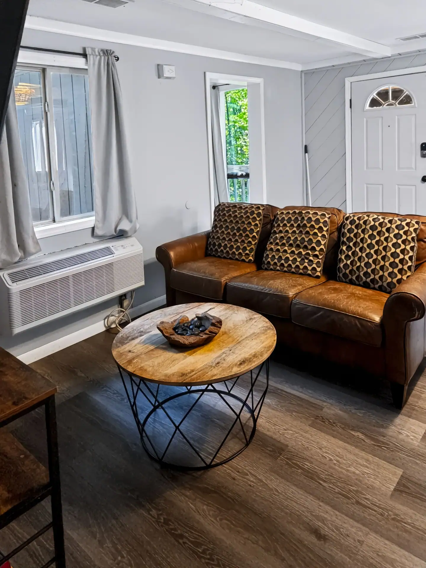 Leather sofa and round wood coffee table in the living room of The Getaway House.