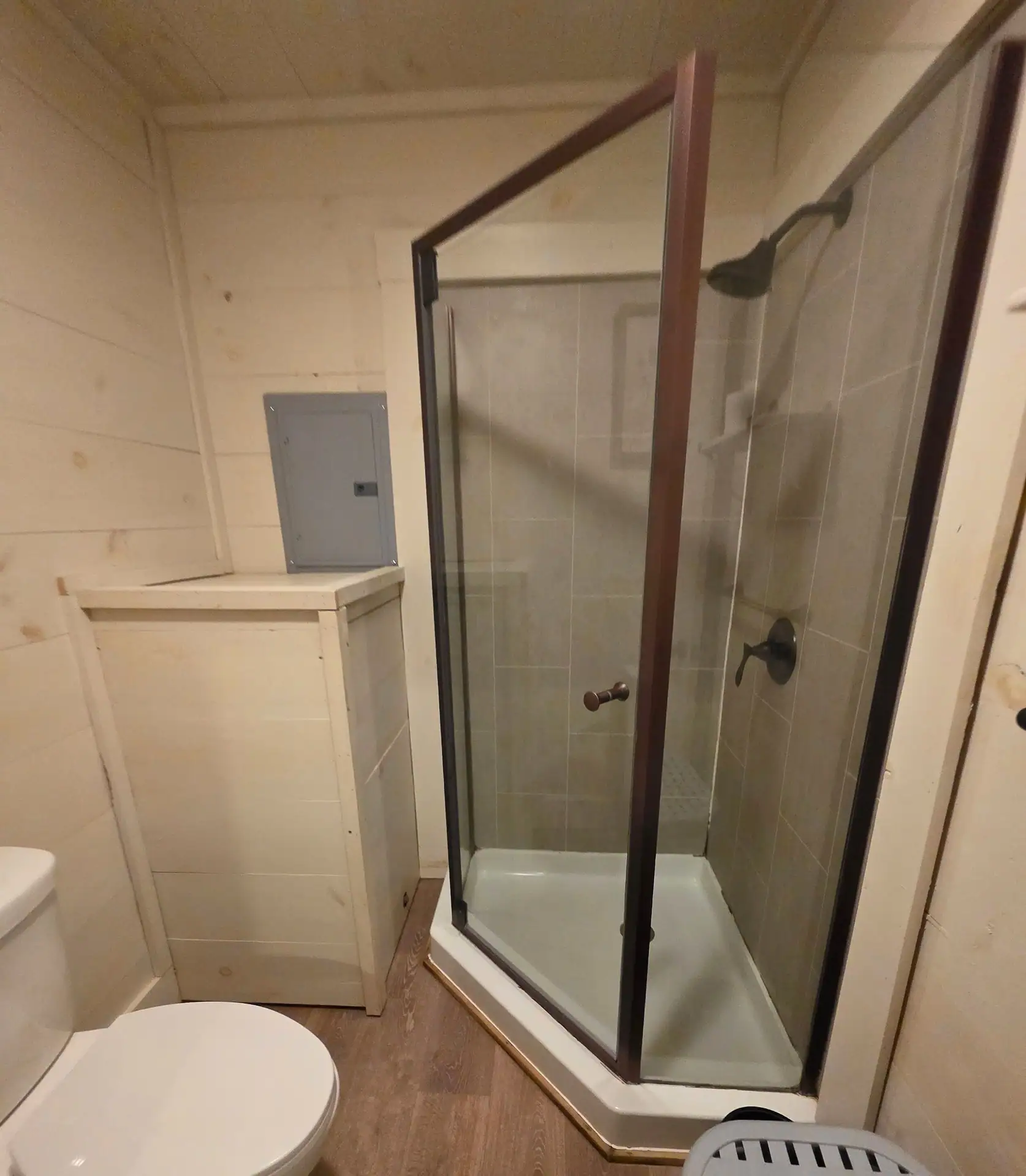 Glass-enclosed corner shower next to the toilet at Hummingbird cabin