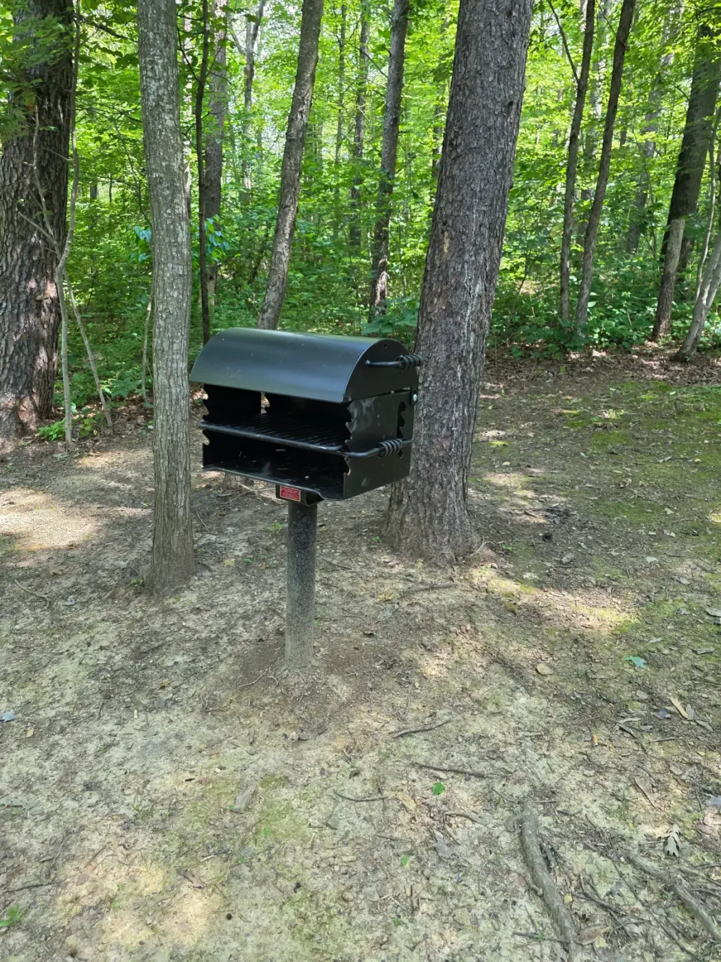 Charcoal grill station in the shaded wooded yard at Millers Den cabin