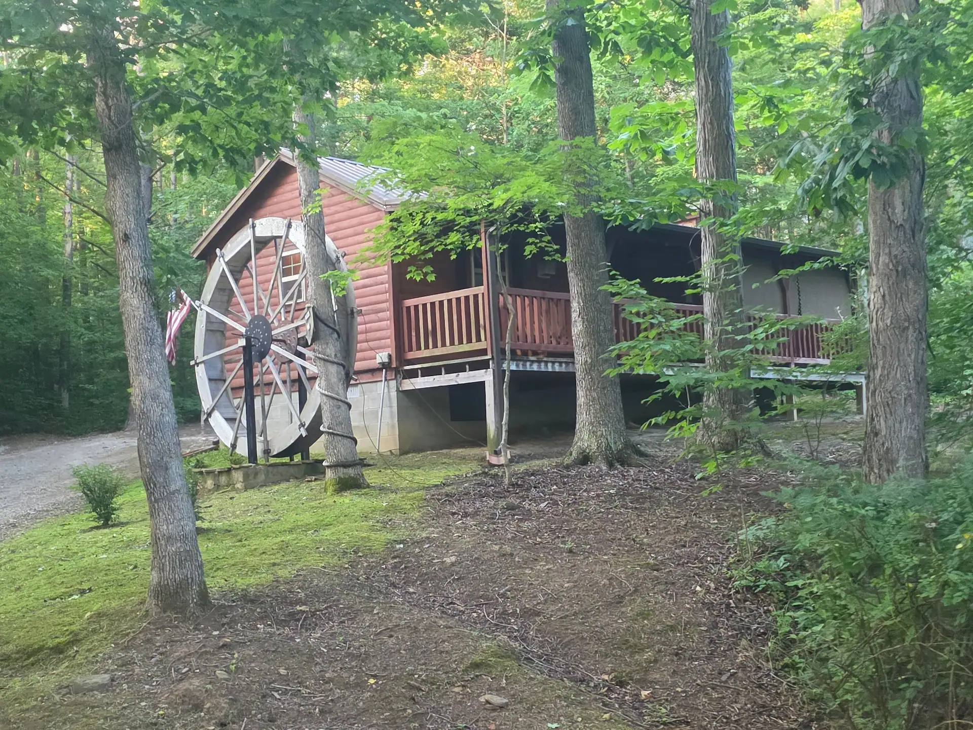 Millers Den cabin with its large water wheel and wraparound deck in the Hocking Hills woods