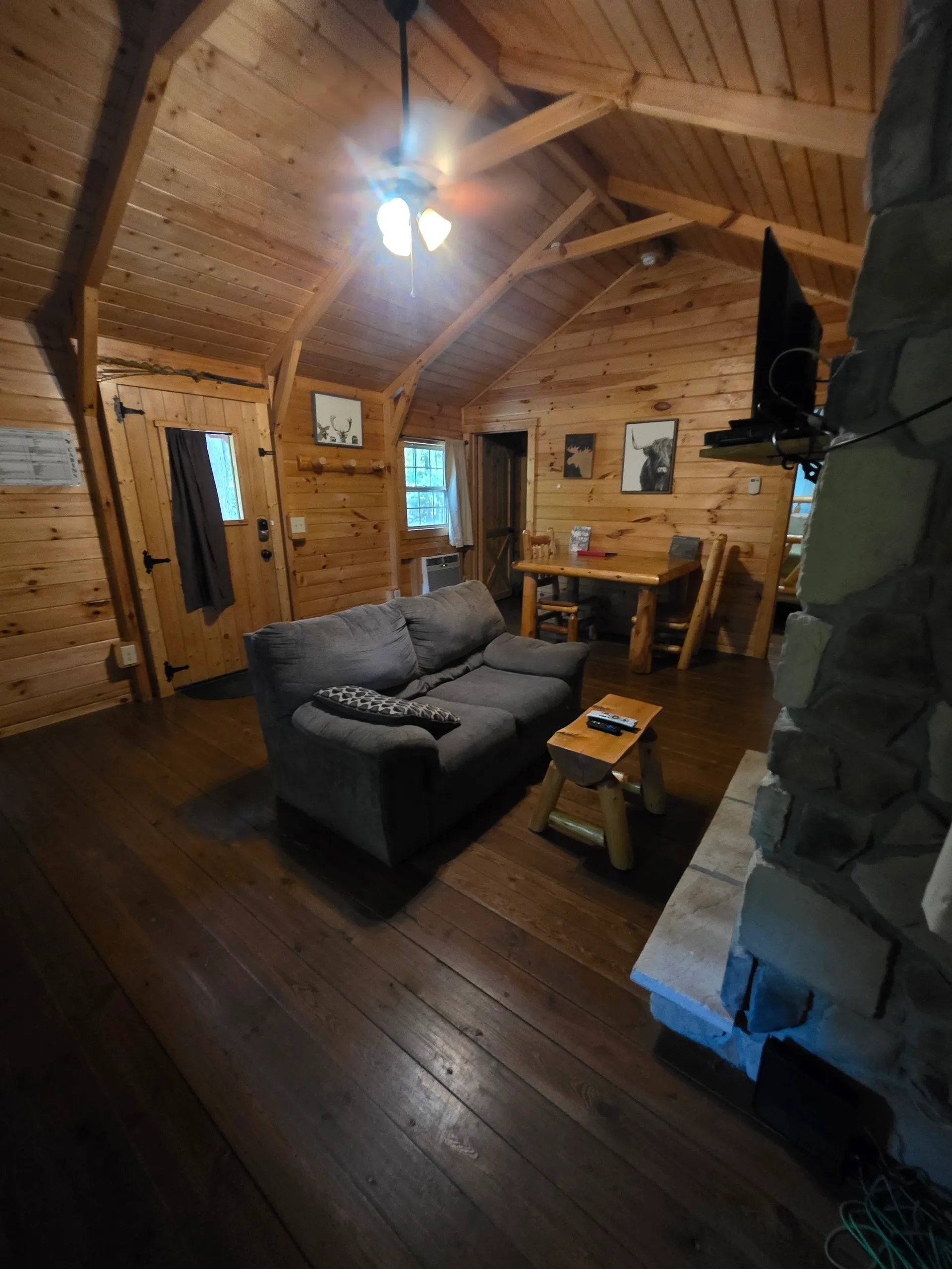 Spacious living room with comfortable sofa and loft above at Millers Den cabin