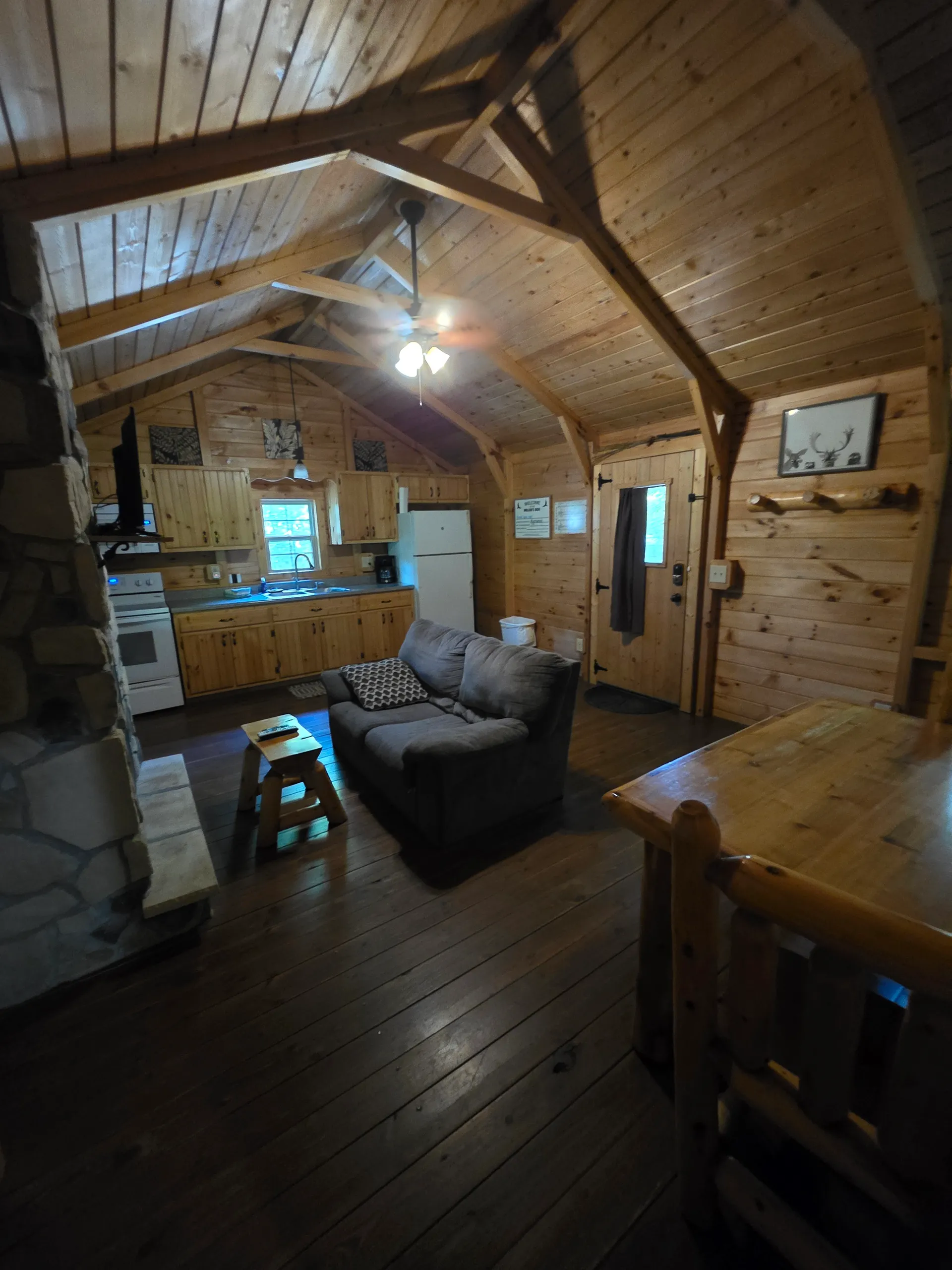 View from loft overlooking the open living area with sofa and kitchen at Millers Den cabin