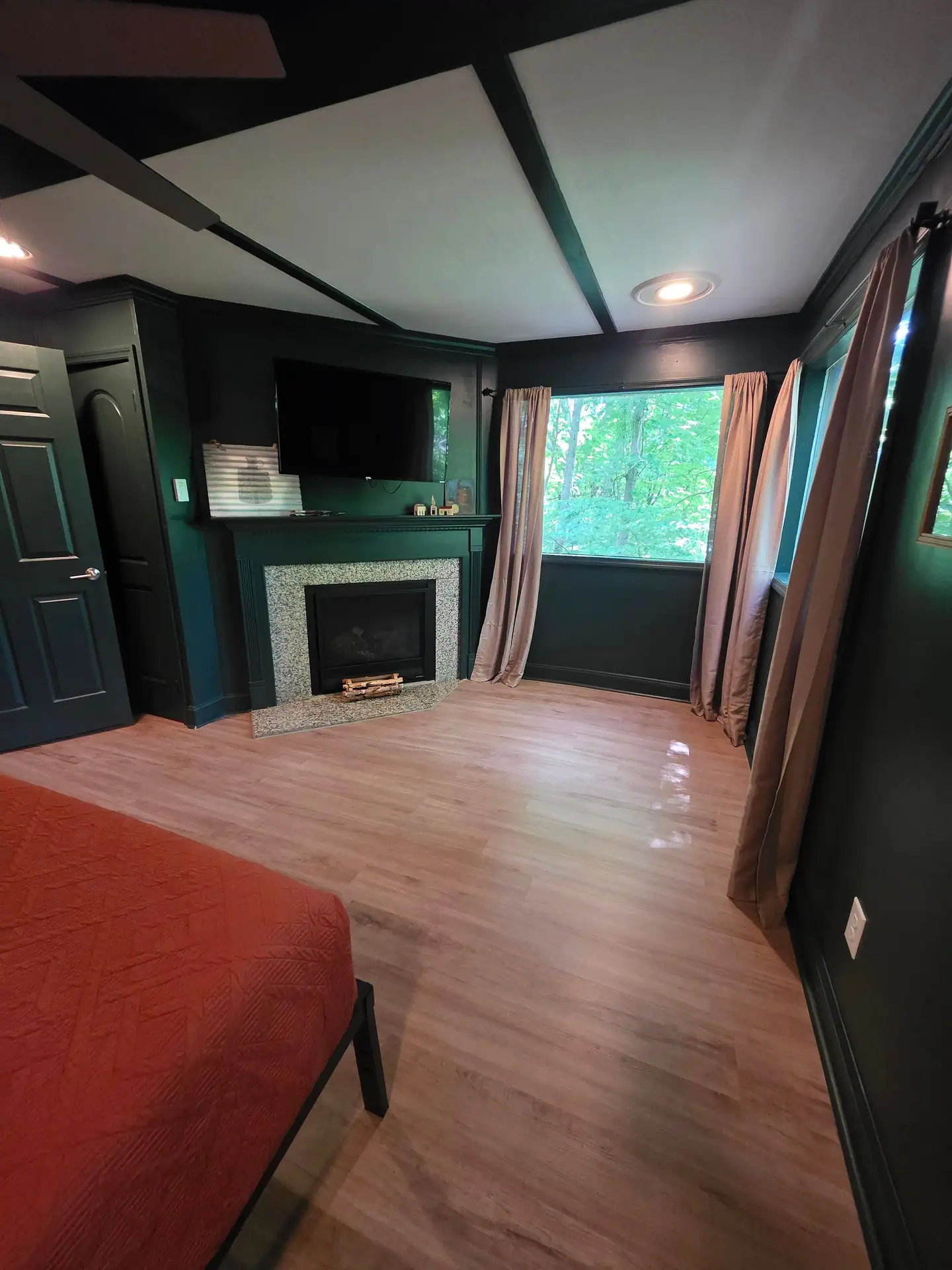 Bedroom with gas fireplace, granite surround and wall-mounted TV at The Old Moonshiner cabin