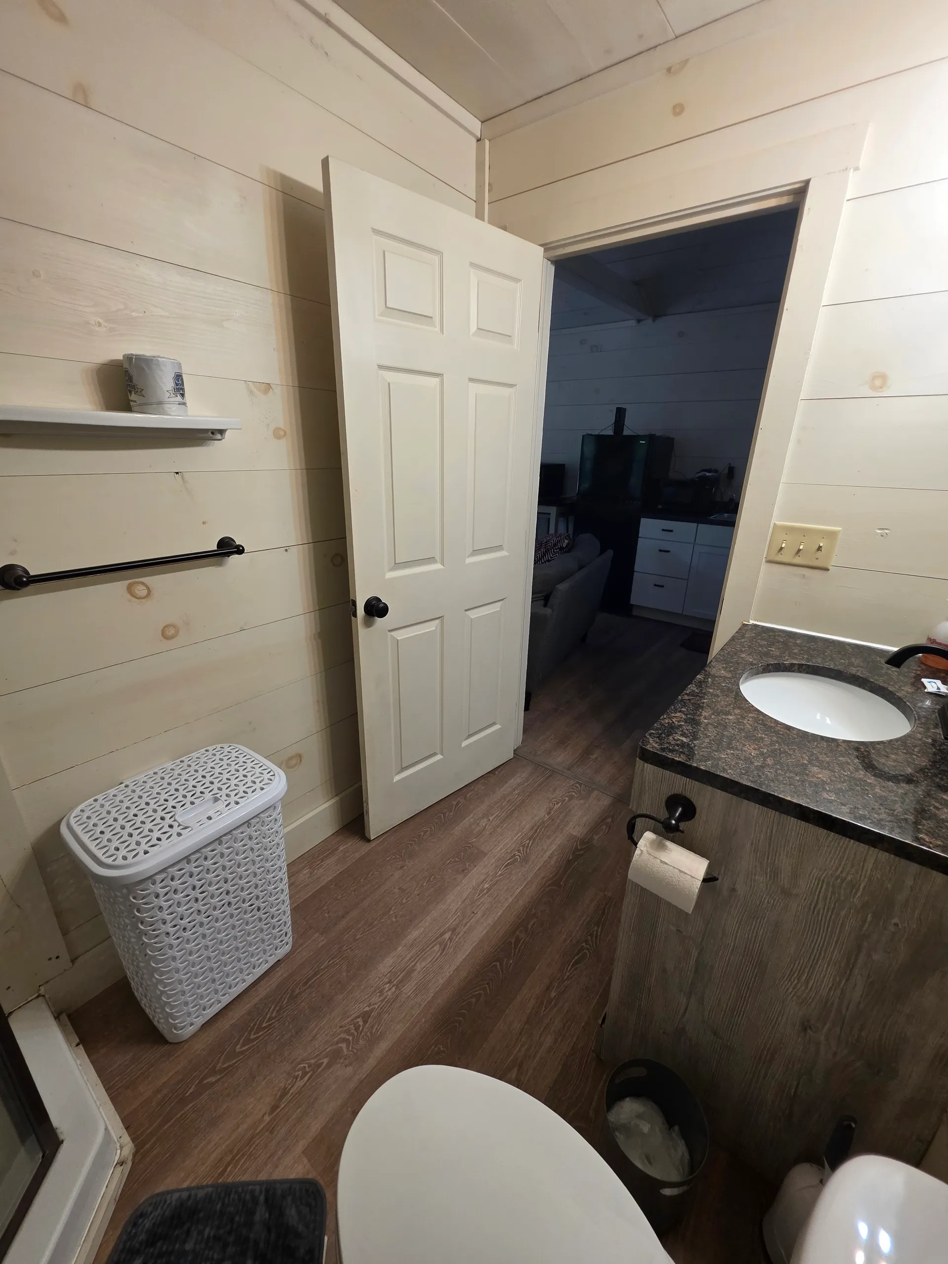 Bathroom layout showing vanity, toilet, and door to the main living area at Owl's Tale cabin