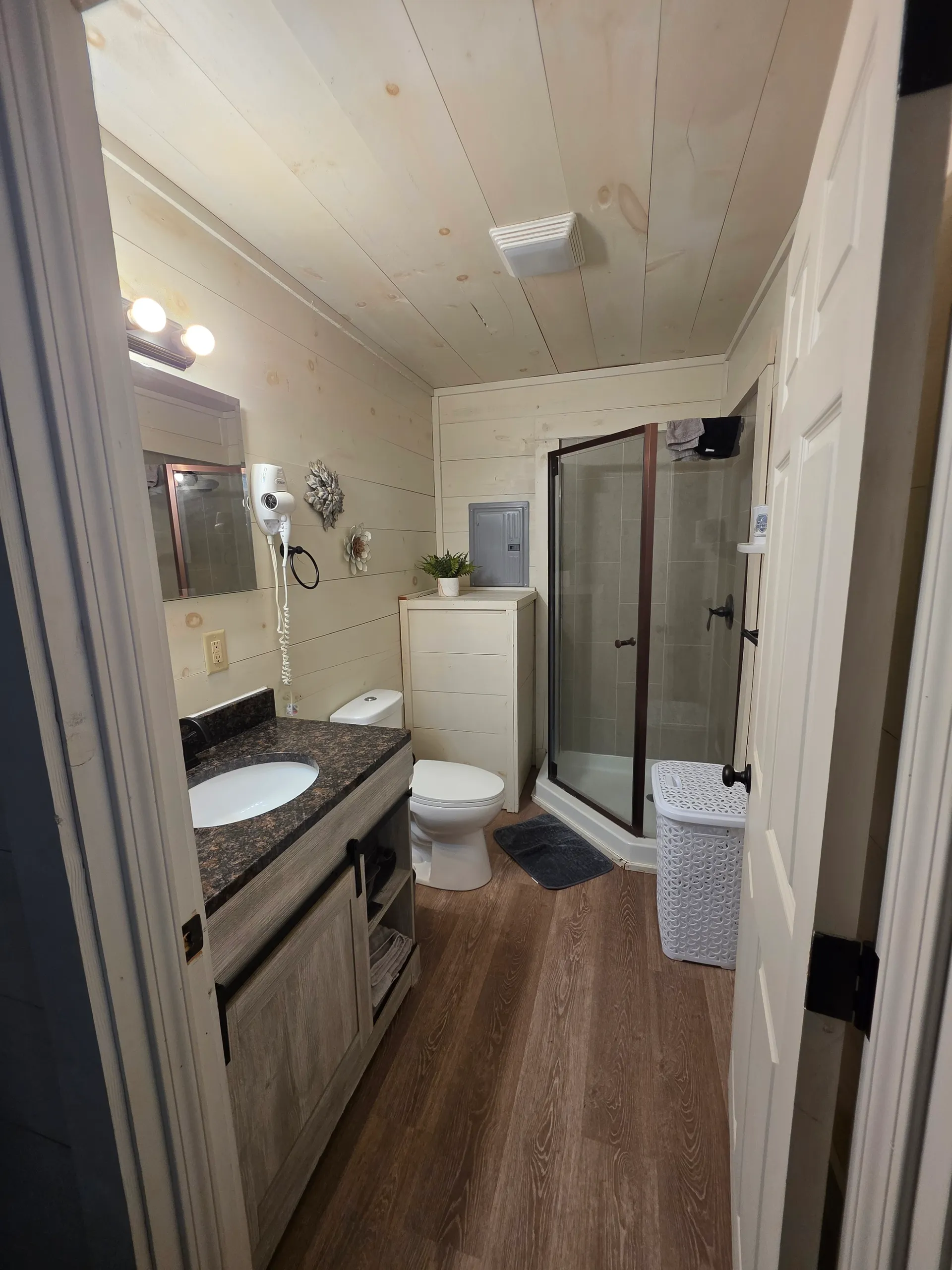Full bathroom with glass shower, vanity with granite counter, and toilet at Owl's Tale cabin