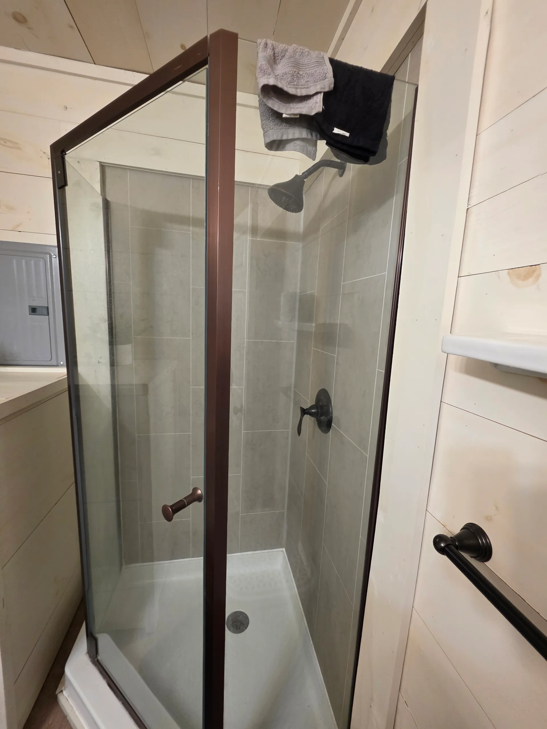 Glass-enclosed walk-in shower with gray tile at Owl's Tale cabin