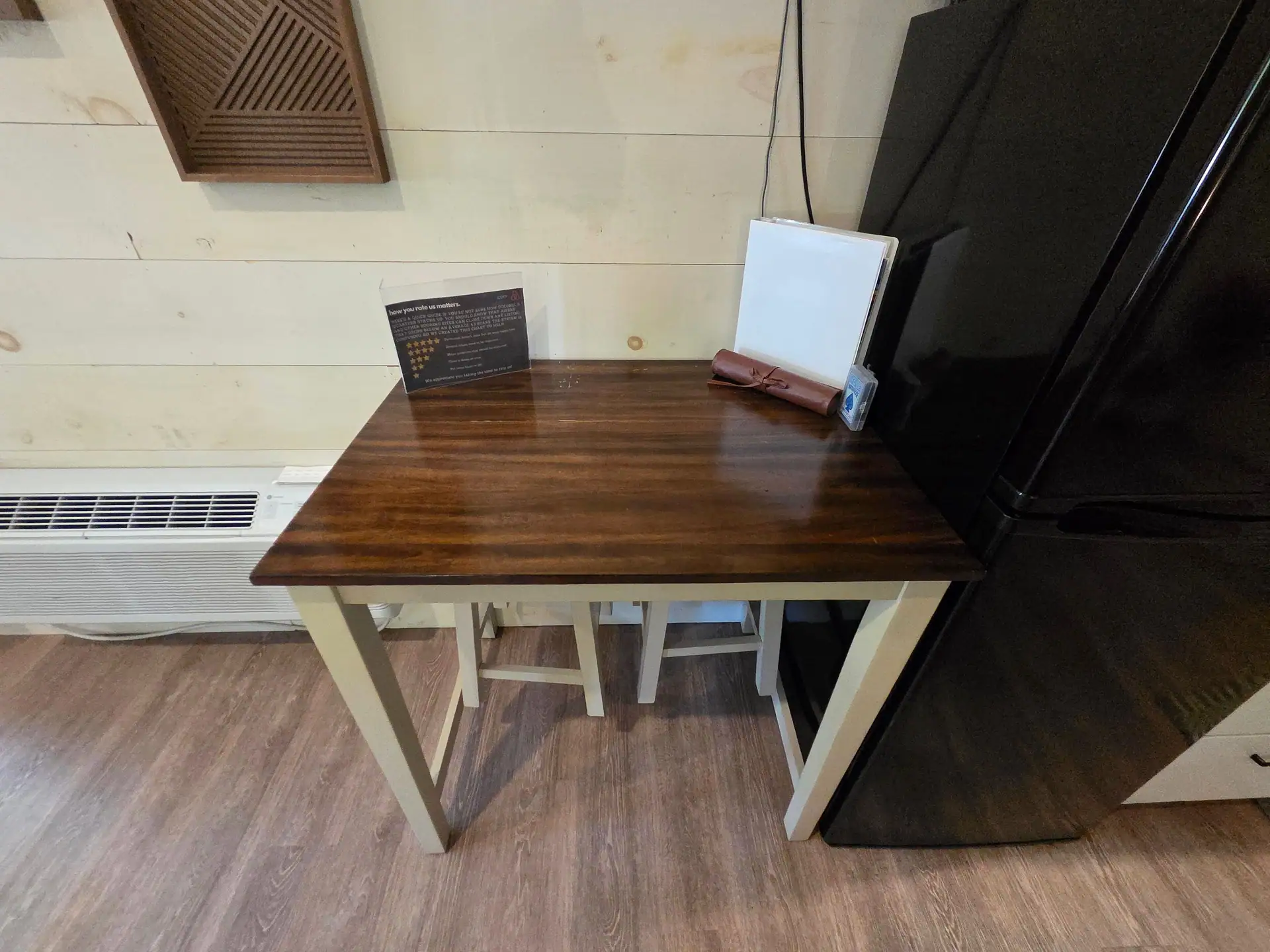 Wood dining table with two stools next to the fridge at Owl's Tale cabin