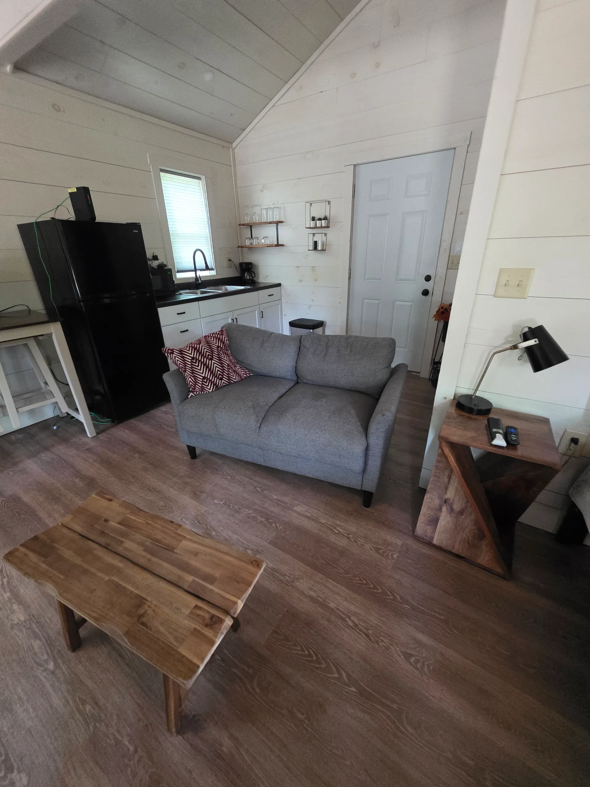 Living room with gray sofa, flat-screen TV, and wood dining table at Owl's Tale cabin