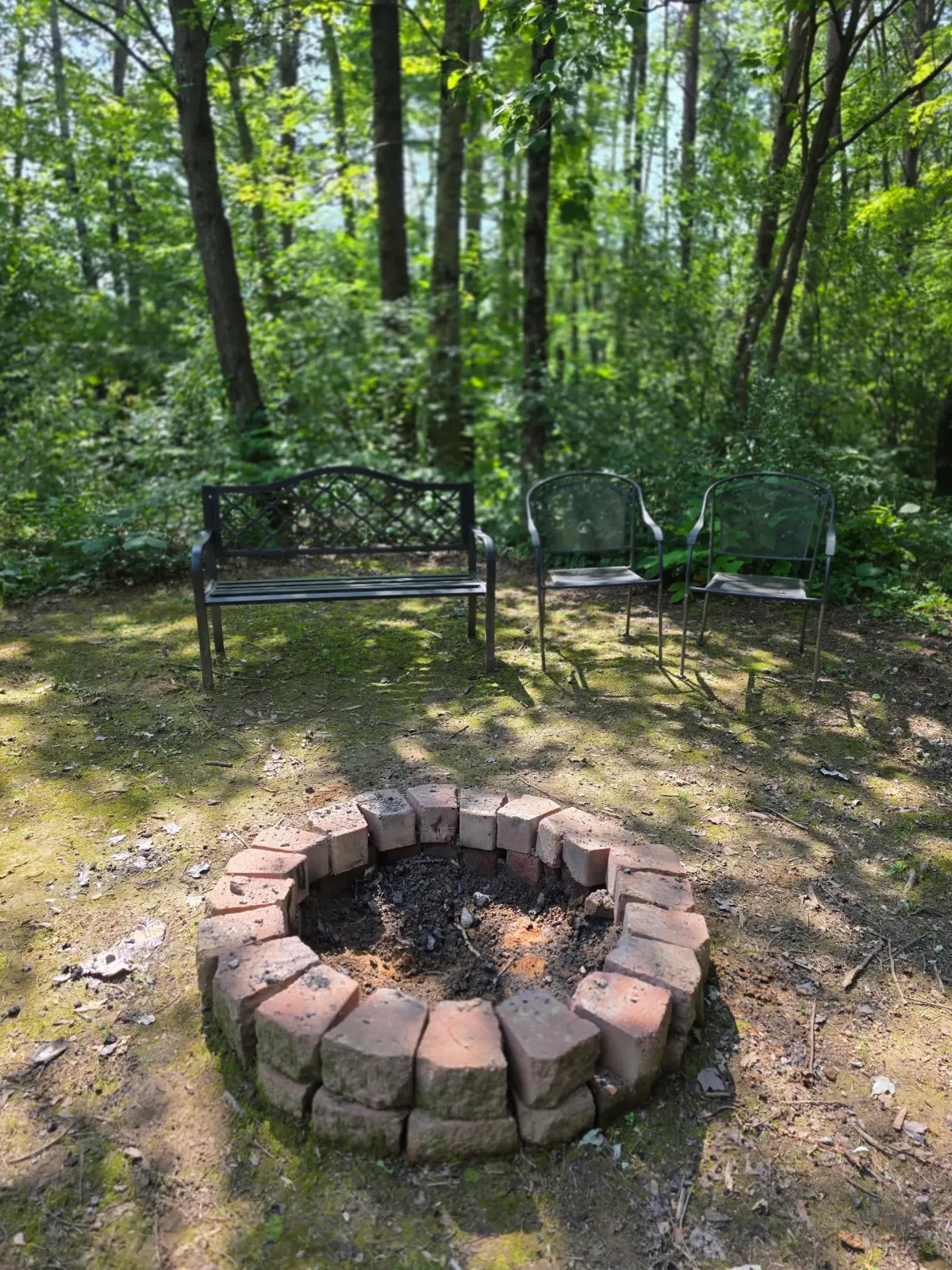 Stone fire pit in the wooded yard at Settlers Roost cabin in Hocking Hills
