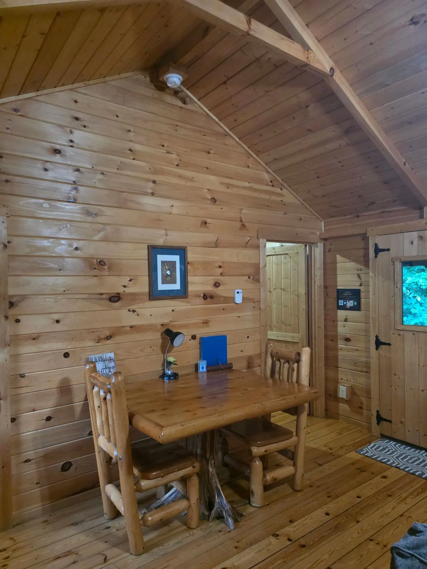 Log dining table with two chairs in the corner of Whippoorwill
