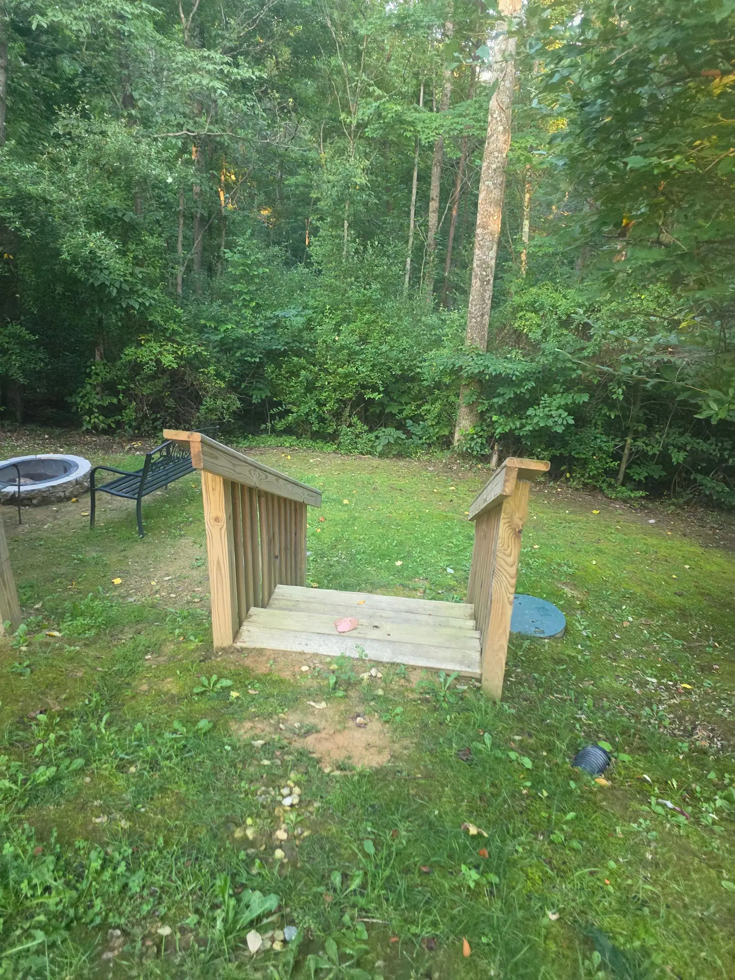 Wooden steps down to the fire pit area in the yard at Whippoorwill