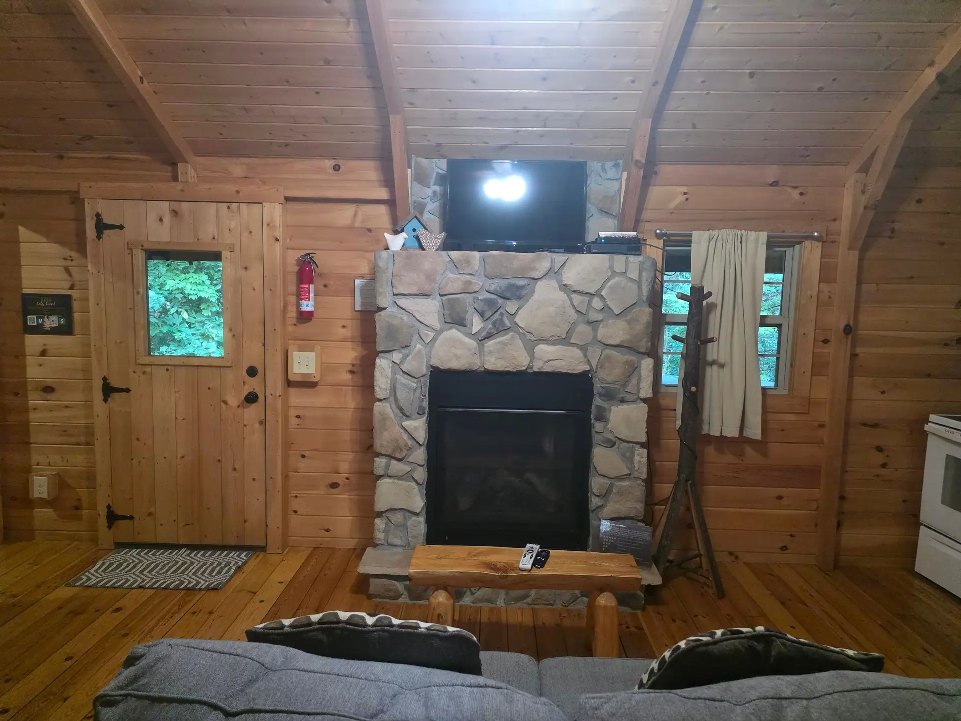 Stone gas fireplace with a TV above in the Whippoorwill living room
