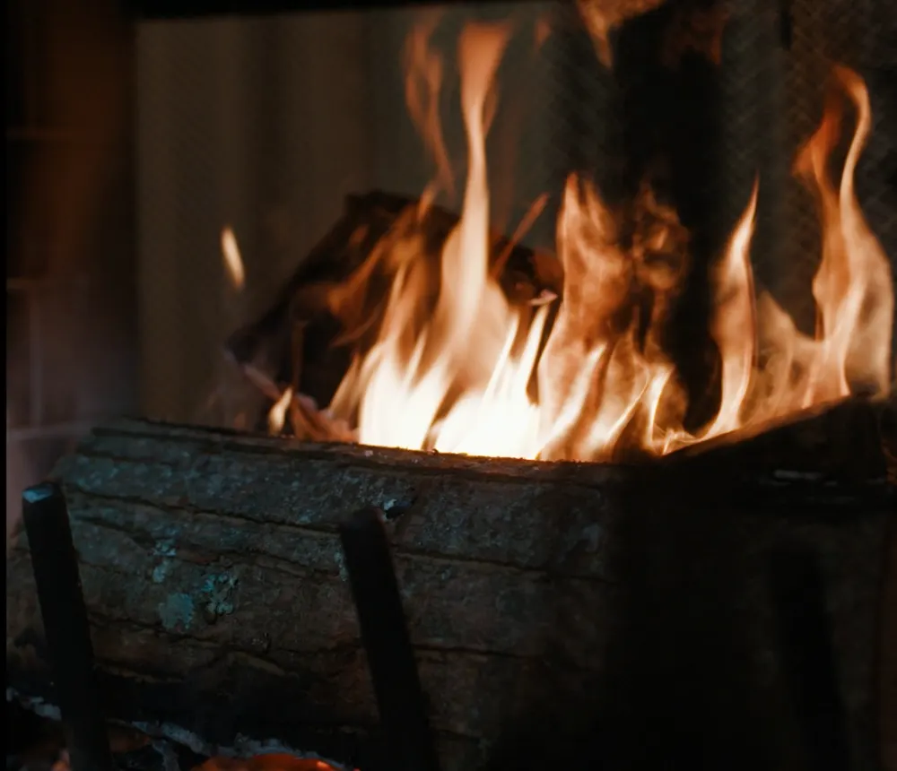 A log burning in the cabin fireplace